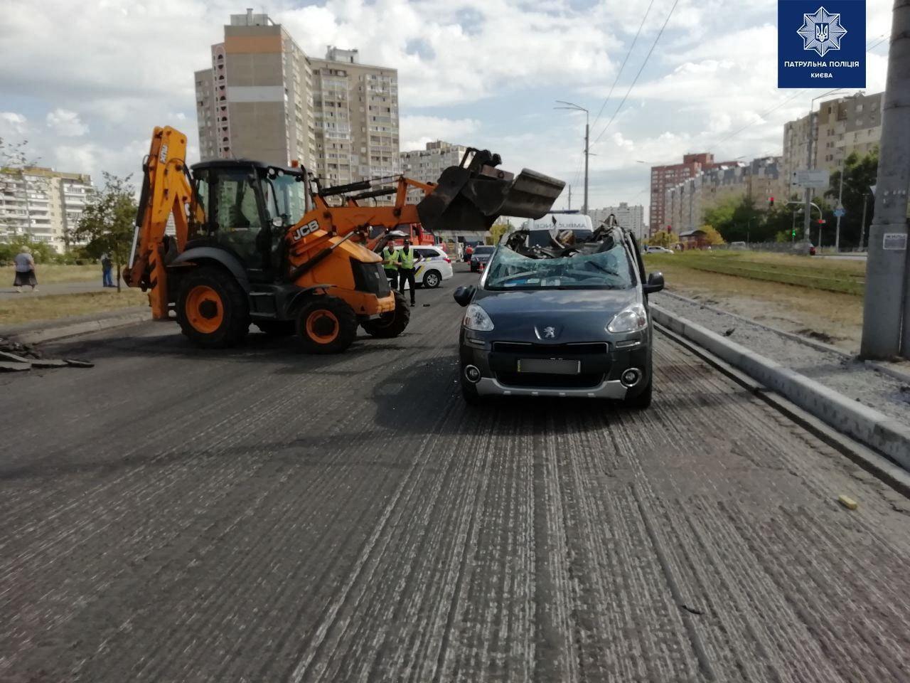 В Киеве крышу авто зацепило ковшом трактора