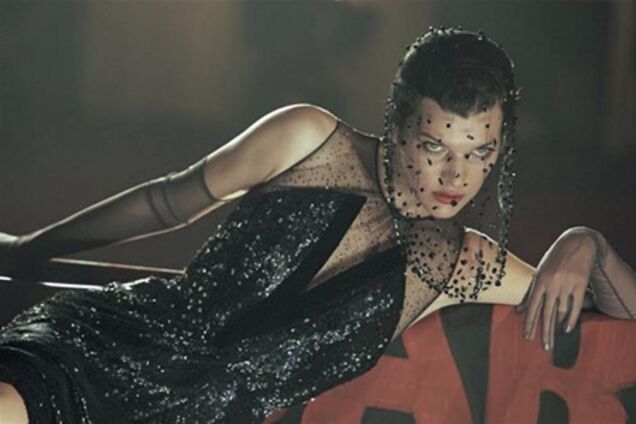 Йовович позирует с транспарантами в руках. Фото