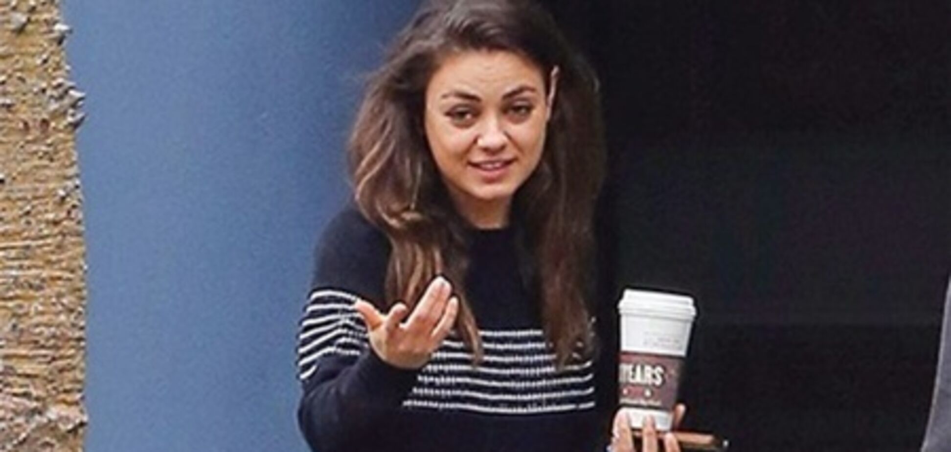 Не накрашенная Кунис 'заправляется' кофе. Фото