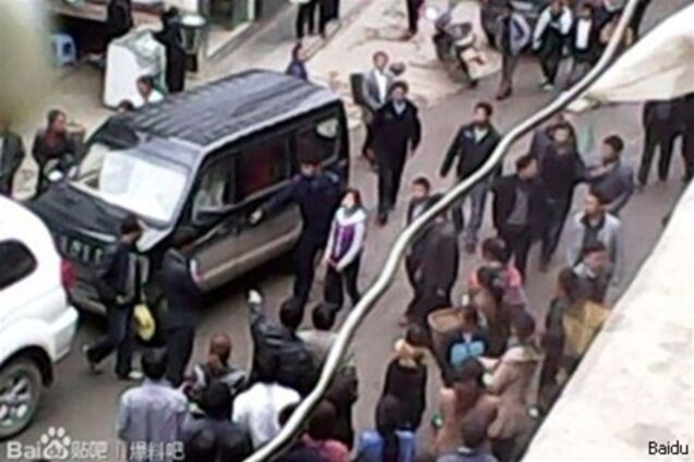 Облившую машину чиновника китаянку провели по городу в наручниках