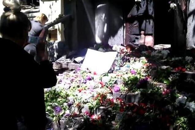 Мариупольцы несут цветы к сожженному зданию милиции