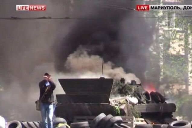 В центре Мариуполя - взрывы и выстрелы, горит БМП. Видеотрансляция