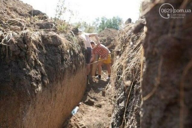 Маріупольці масово копають рови на підступах до міста
