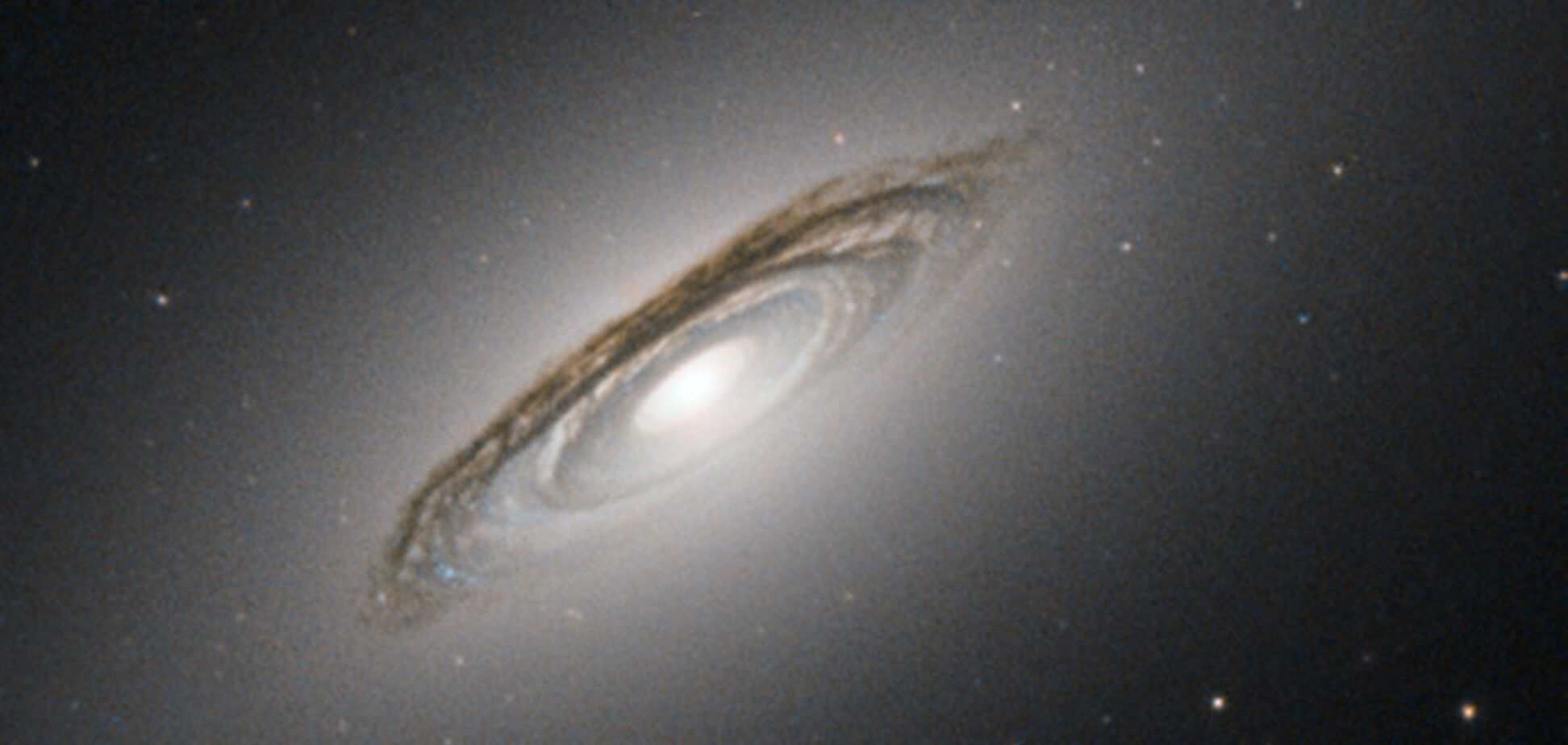 Hubble заснял редкую линзовидную галактику в пыли