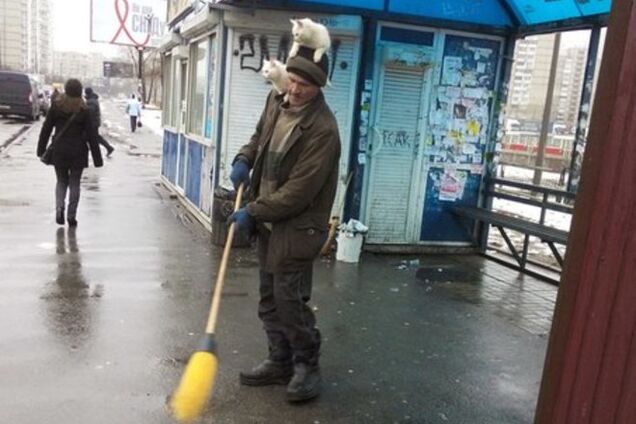 В Киеве дворник заметает улицу с двумя котами на голове: фотофакт