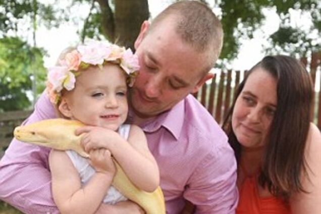 Смелая 2-летняя девочка играет в обнимку с гигантским питоном