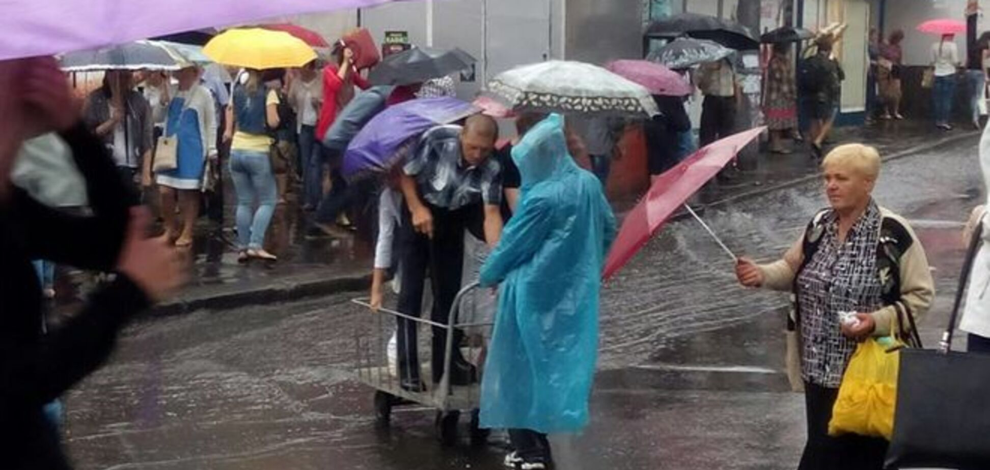 У Києві пішоходи 'перепливали' через залиту дощем вулицю на візку: фотофакт