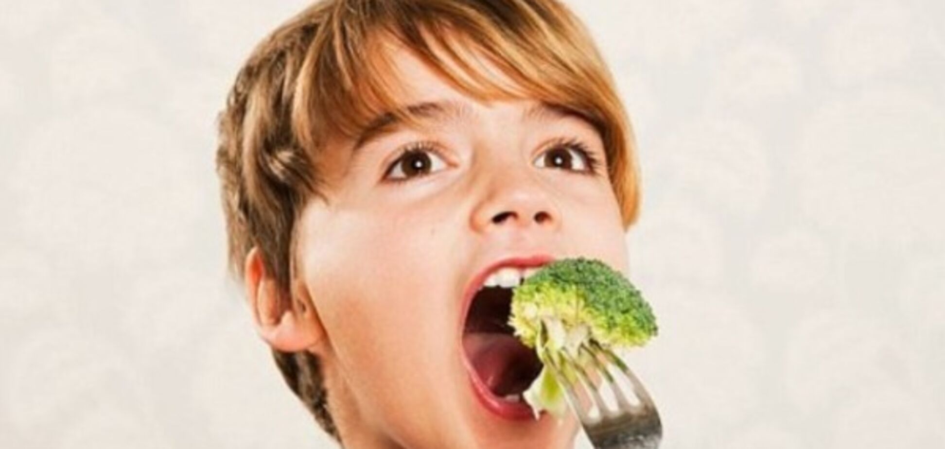 Мальчик ест брокколи