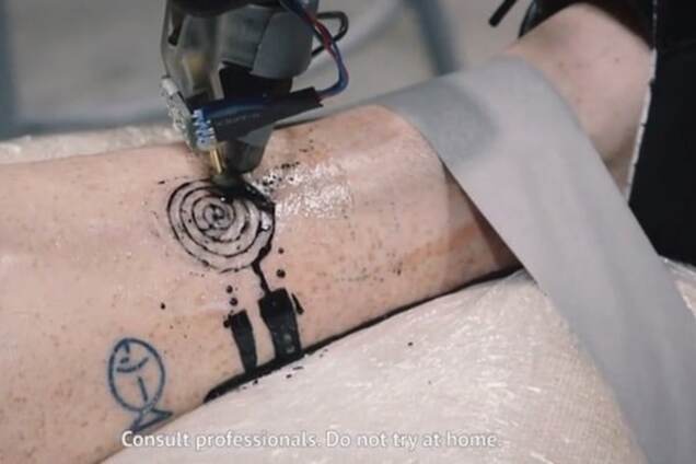 Во Франции промышленный робот научился делать татуировки на теле человека: видеофакт