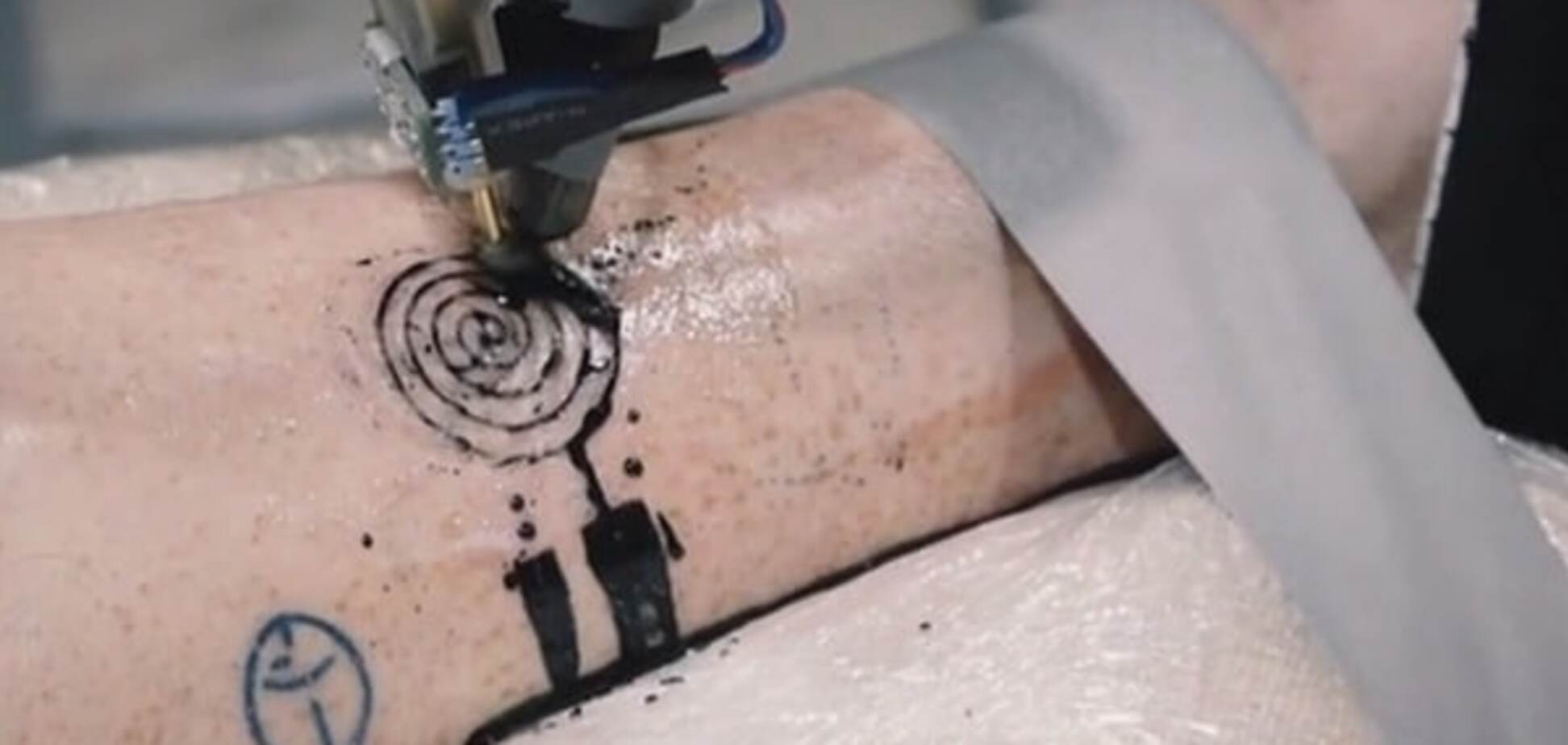 Во Франции промышленный робот научился делать татуировки на теле человека: видеофакт