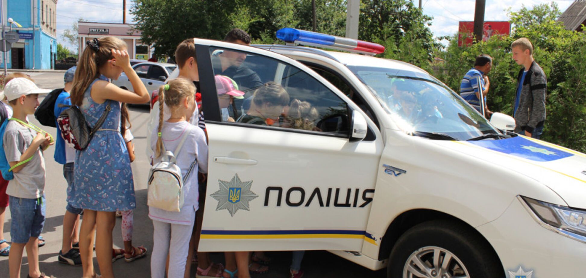 Патрульні покатають дітей на поліцейських машинах