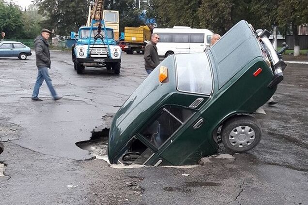 Під Києвом таксі звалилося у пекельне провалля на дорозі: фото і відео НП