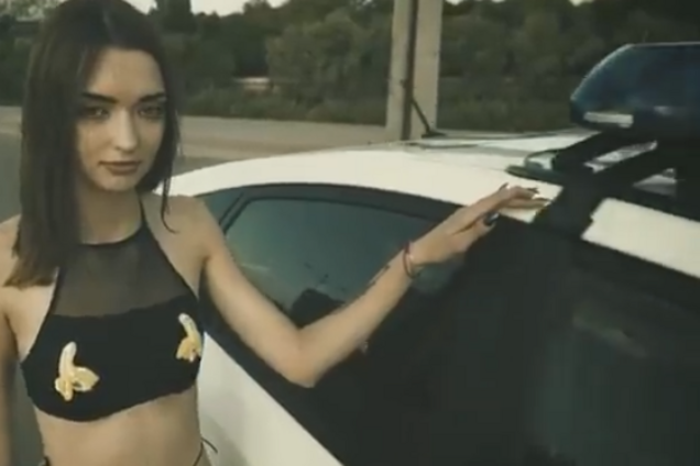 Дівчина біля авто поліції