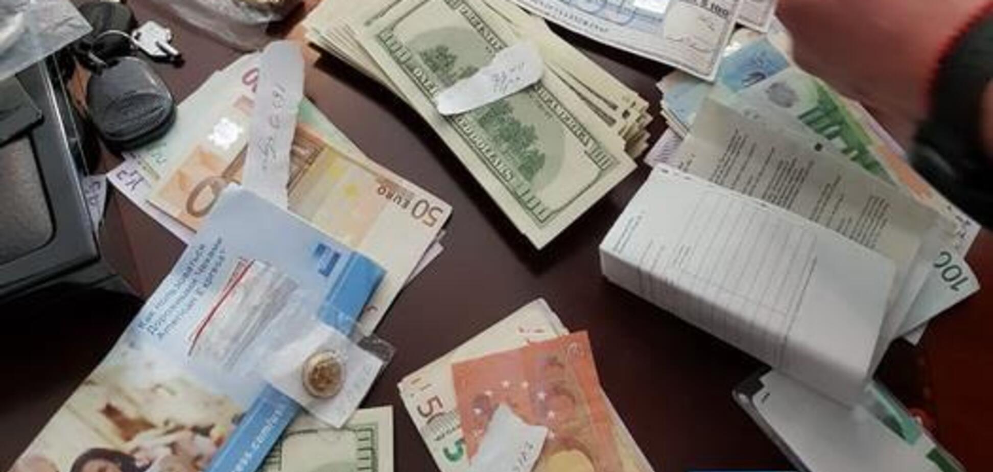 Кучи денег, золото и оружие: в Украине накрыли финансовую пирамиду