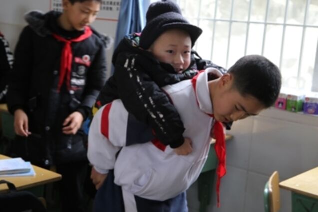 Школяр кожен день носить паралізованого товариша на навчання: ось їх зворушлива історія