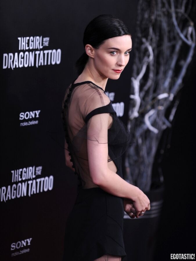 Девушка с татуировкой дракона на красной дорожке. В очень странном платье