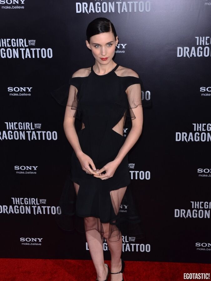 Девушка с татуировкой дракона на красной дорожке. В очень странном платье