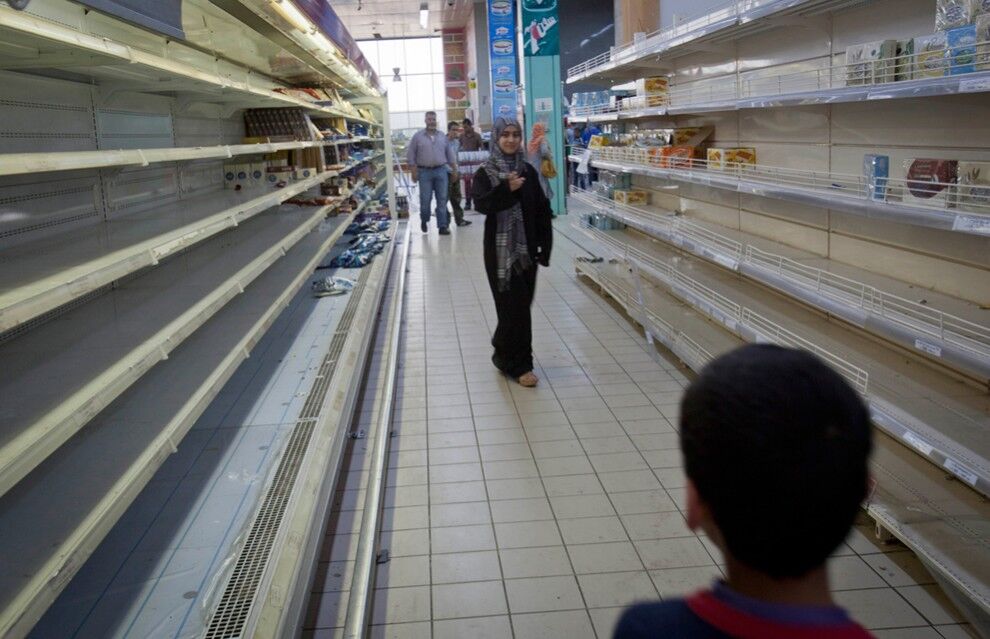 9. Ливийцы в практически пустом магазине в Триполи. (AP Photo/Darko Bandic)