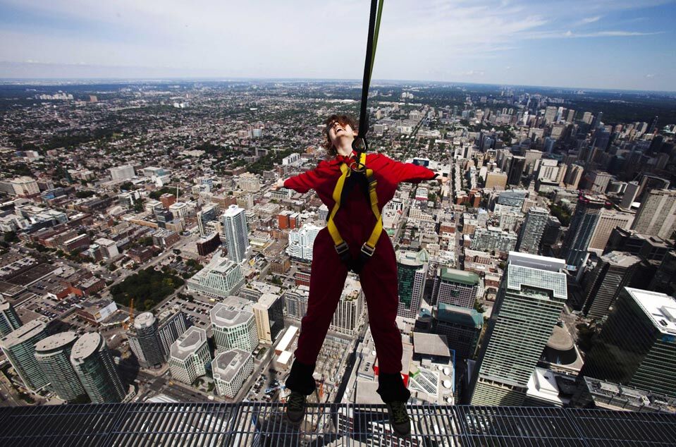 15. Репортерша на краю платформы во время представления аттракциона EdgeWalk на телебашне в Торонто. Любителям экстрима предлагается пройтись по подиму на высоте 356 метров со страховкой. (Mark Blinch/Reuters)