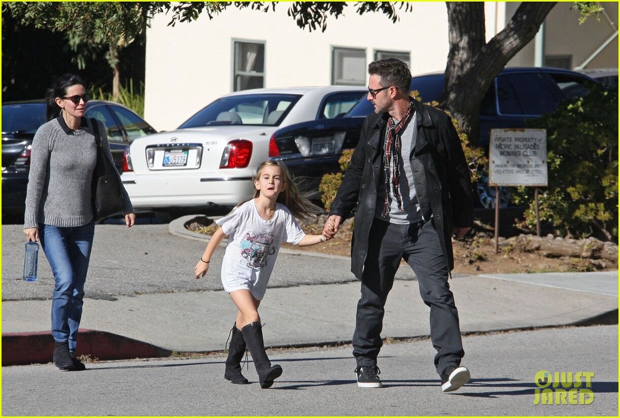 Кокс с семьей идет к авто. Фото