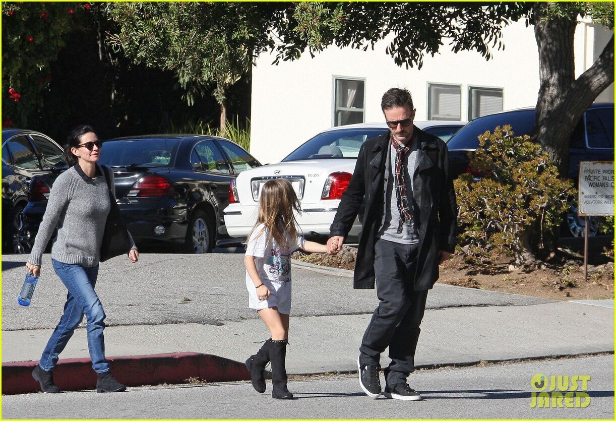 Кокс с семьей идет к авто. Фото