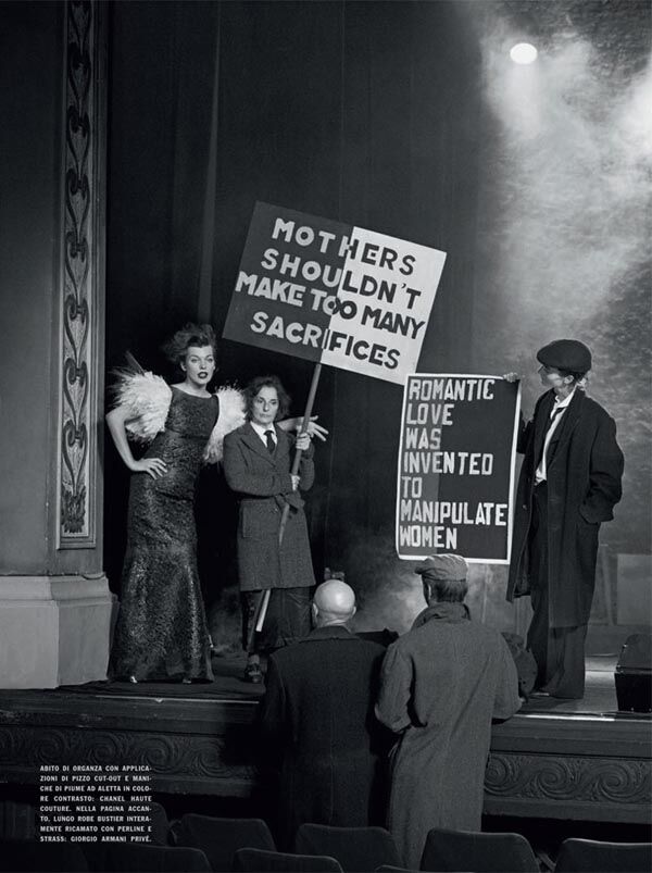 Йовович позирует с транспарантами в руках. Фото