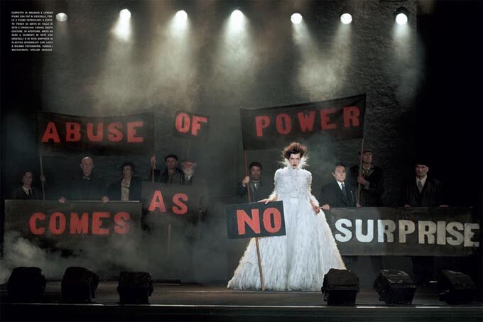 Йовович позирует с транспарантами в руках. Фото