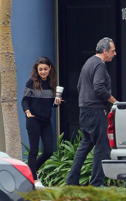 Не накрашенная Кунис "заправляется" кофе. Фото