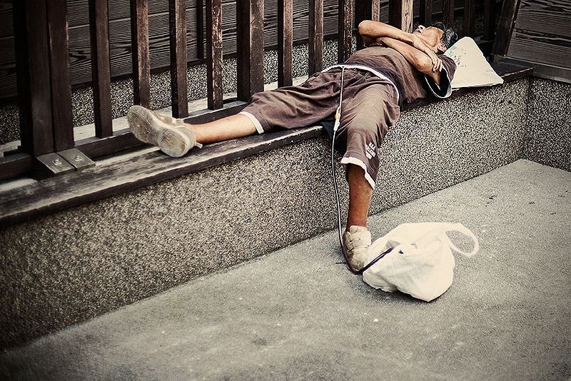 Виснажені роботою жителі Токіо, сплячі на вулиці