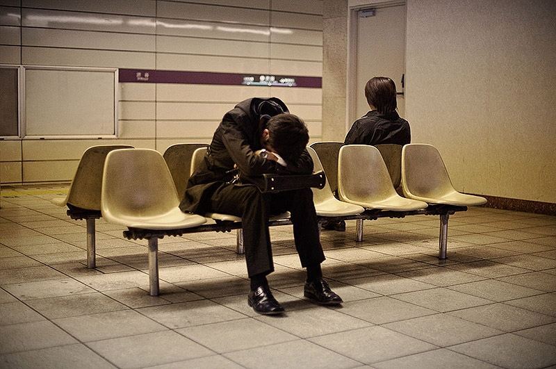 Изнуренные работой жители Токио, спящие на улице
