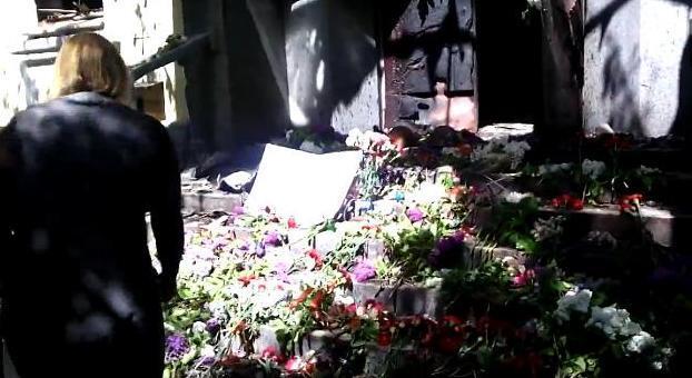 Мариупольцы несут цветы к сожженному зданию милиции