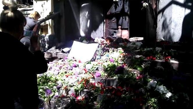 Маріупольці несуть квіти до спаленому будівлі міліції