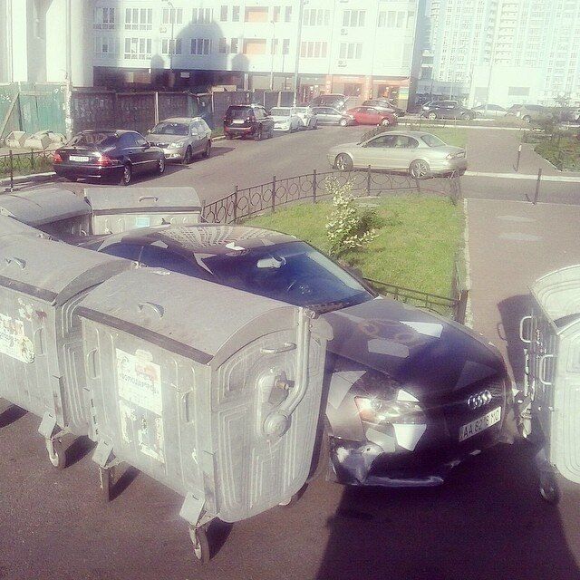 В Киеве неправильно припаркованное авто заблокировали мусорными баками. Фотофакт