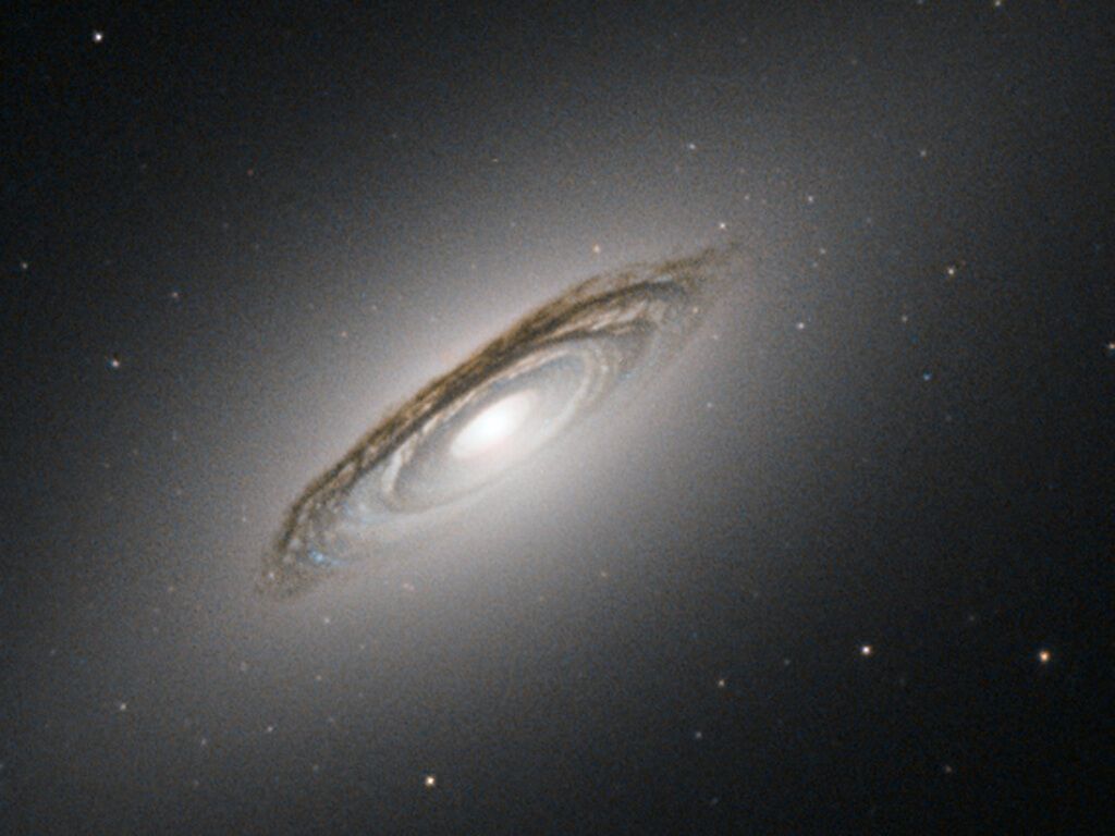 Hubble заснял редкую линзовидную галактику в пыли