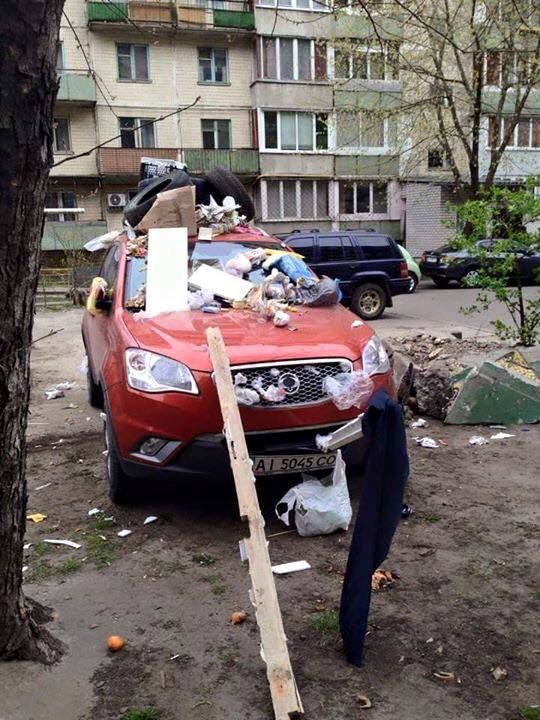 В Киеве забросали мусором припаркованную на газоне иномарку: фотофакт