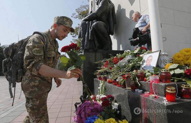 Киевляне продолжают нести цветы к месту гибели бойцов под Радой