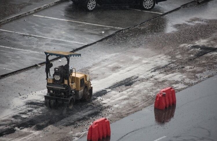 В Киеве коммунальщики под дождем начали класть асфальт: опубликованы фото