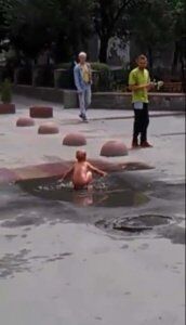 "Водні процедури" на асфальті: в мережі з'явилось відео, де голий малюк купається в калюжі посеред дороги