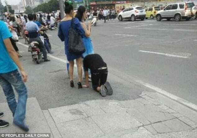 Китаянка пройшлася по вулиці з чоловіком на повідку