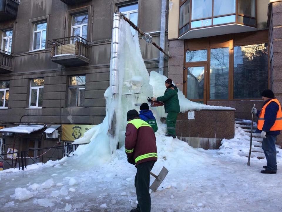 В Киеве коммунальщики с бензопилой борются с "ледником"-гигантом: опубликованы фото
