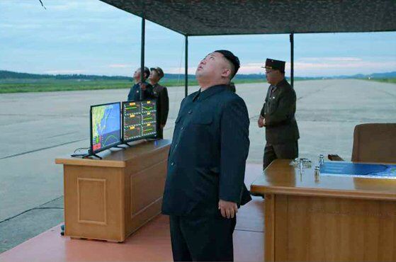 Появились фото Ким Чен Ына на фоне запущенной баллистической ракеты