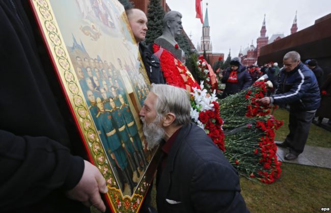 Відзначення дня народження Йосипа Сталіна на його могилі біля Кремлівської стіни на Червоній площі. Чоловік цілує ікону із зображенням радянського диктатора. Москва, 21 грудня 2015 року