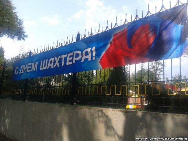 Троянда – символ Донецька в кольорах прапору "ДНР" на банері з нагоди Дня Шахтаря