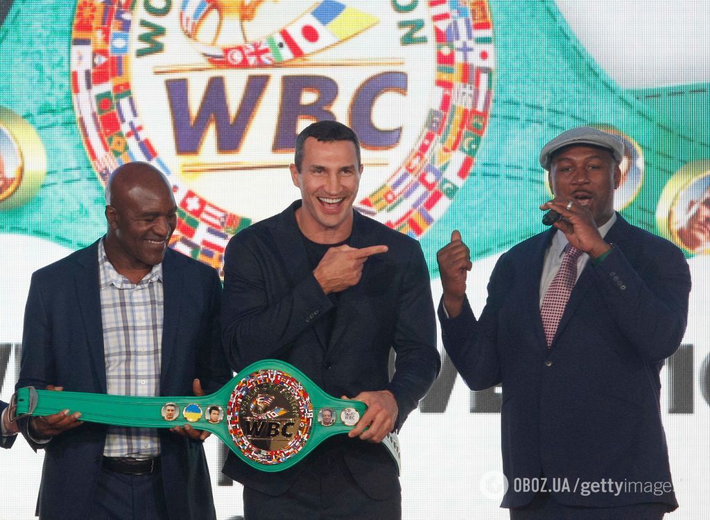 Евандер Холіфілд (зліва) і Леннокс Льюїс вручають Володимиру Кличку чемпіонський пояс WBC