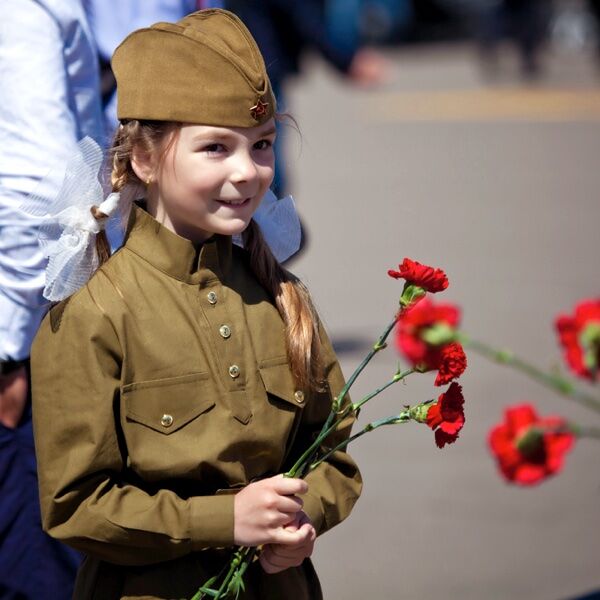Девочка с цветами в военной форме на День Победы