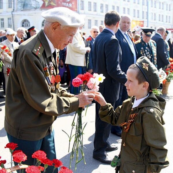 Мальчик дарит цветы ветерану День Победы