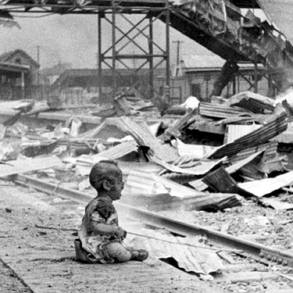 Плачущий китайский ребенок на платформе разбомбленной железнодорожной станции "Юг" в Шанхае