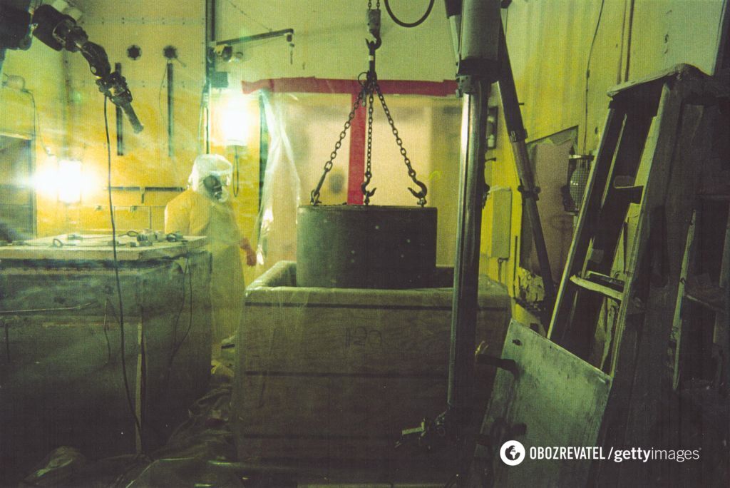 Рабочий загружает топливный растворитель в деревянные вкладыши для подготовки к захоронению в качестве радиоактивных отходов, США