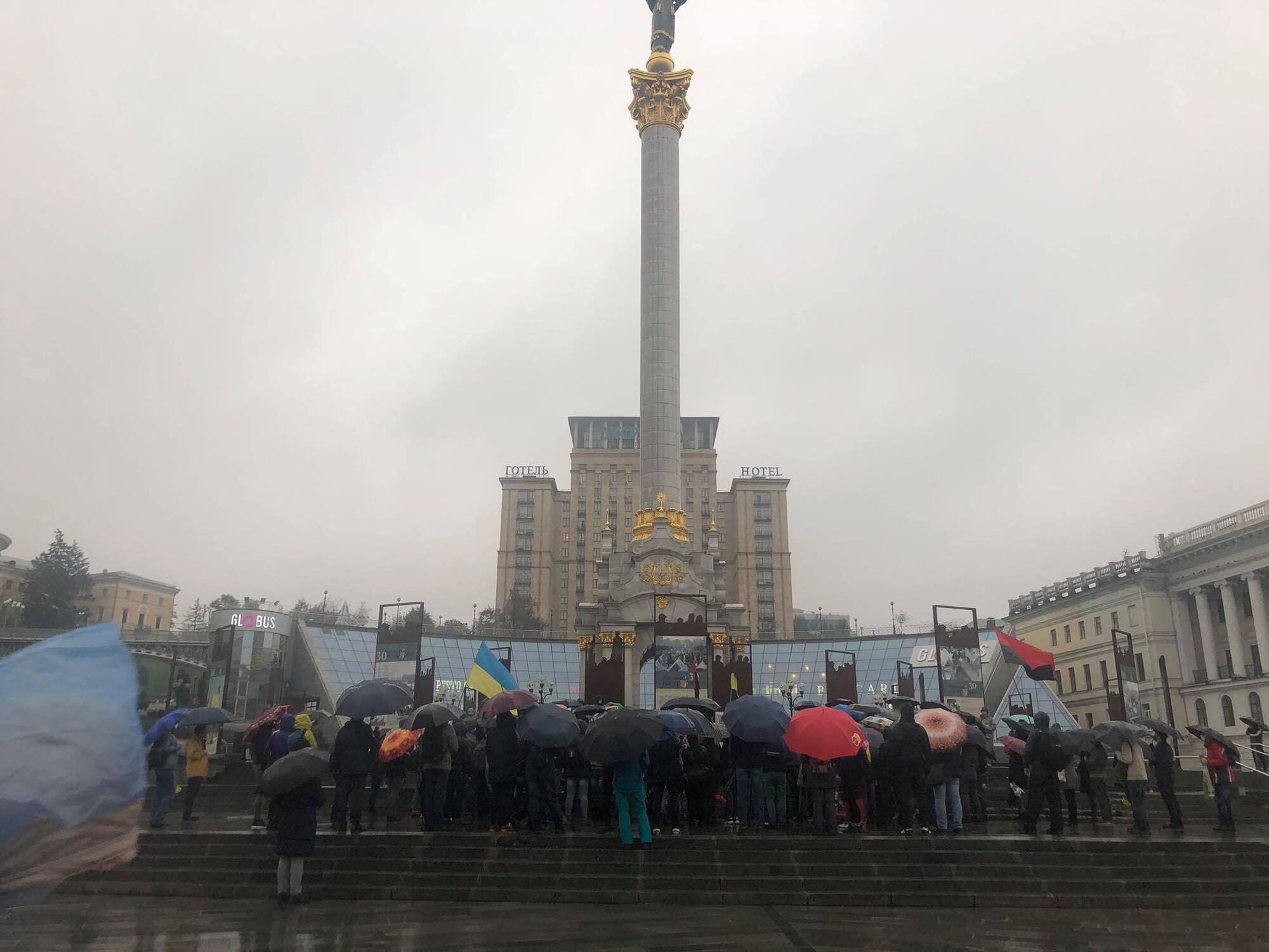 Люди собрались под дождем в центре Киеве.