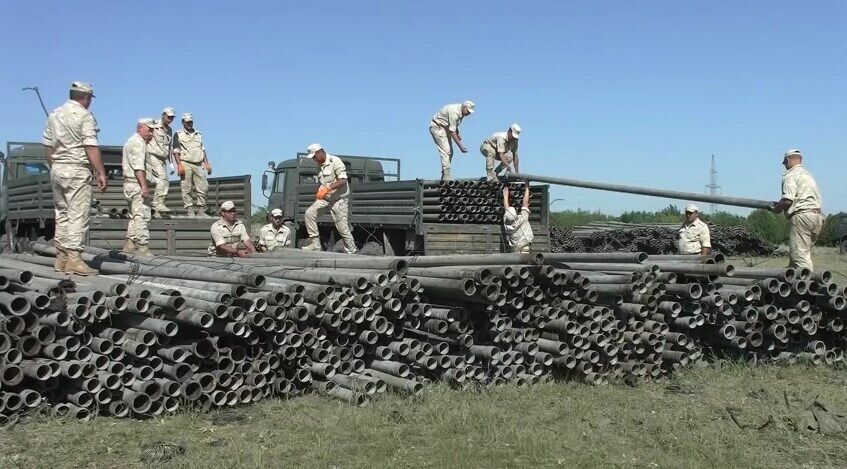 Оккупанты в Крыму разгружают трубы для водопровода.